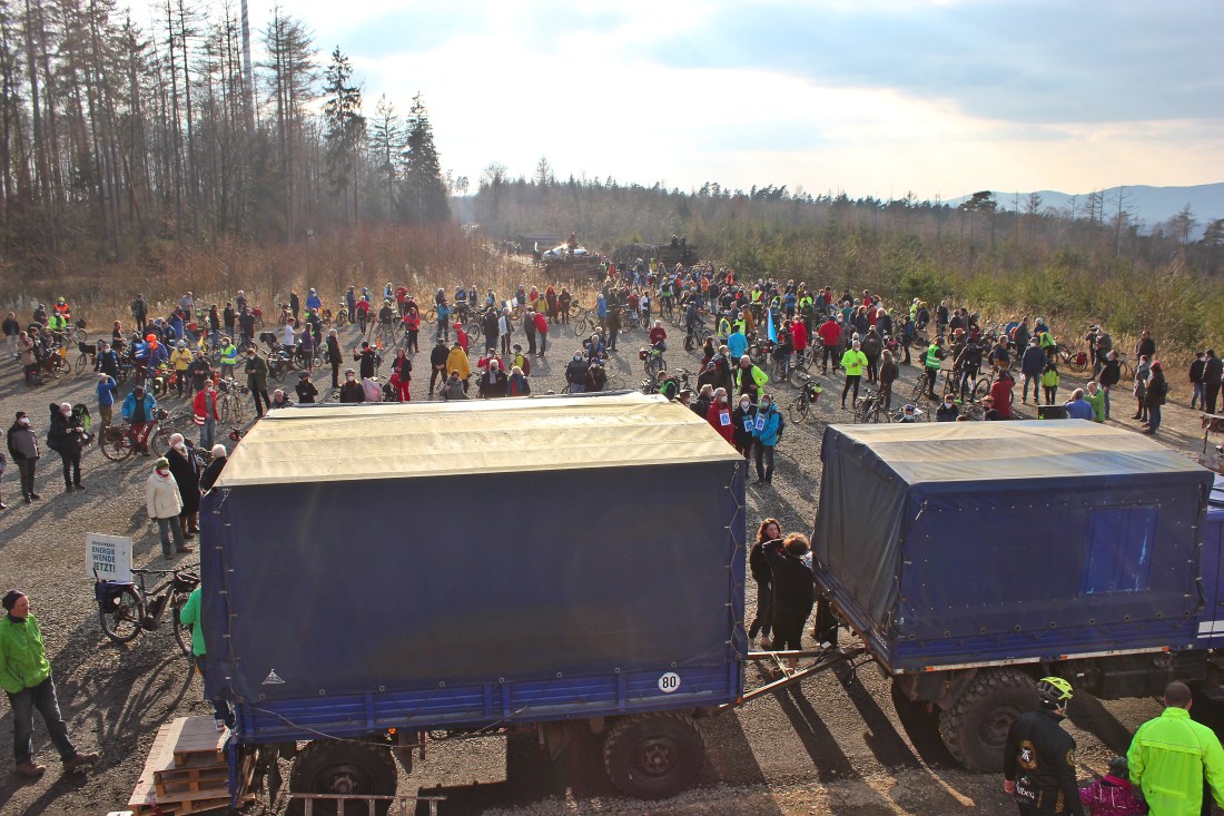 Hunderte Menschen vor der Demobühne unter einem der Windräder im Söhrewald